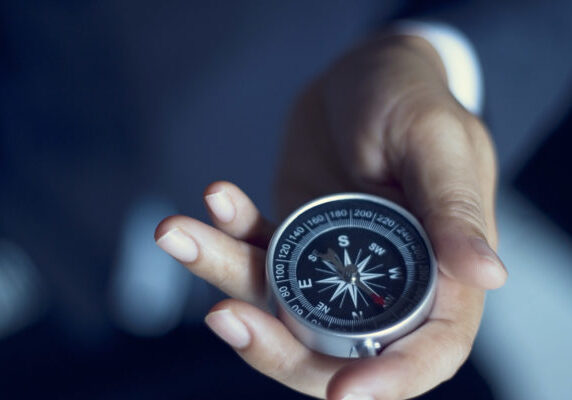 Businessman with a compass holding in hand, color tone film look